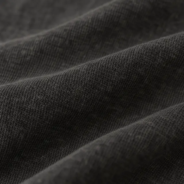 Heavy washed black jersey, softly folded, its faint charcoal tone.