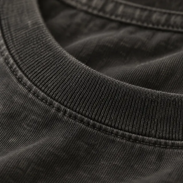 The ribbed neckline of a washed black tee, the black faded a little toward charcoal.