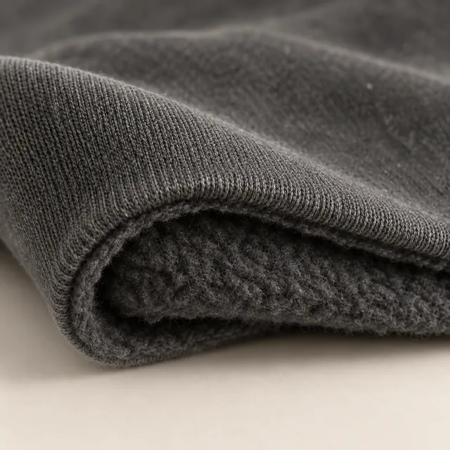 The folded edge of black fleece: a smooth face over a soft back.