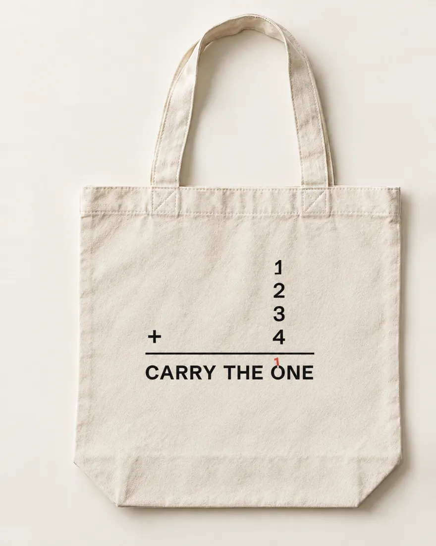 A natural canvas tote laid flat: 1, 2, 3 and 4 stacked as a sum with a plus and a rule, and Carry the One as the answer, a small red 1 carried over its O.