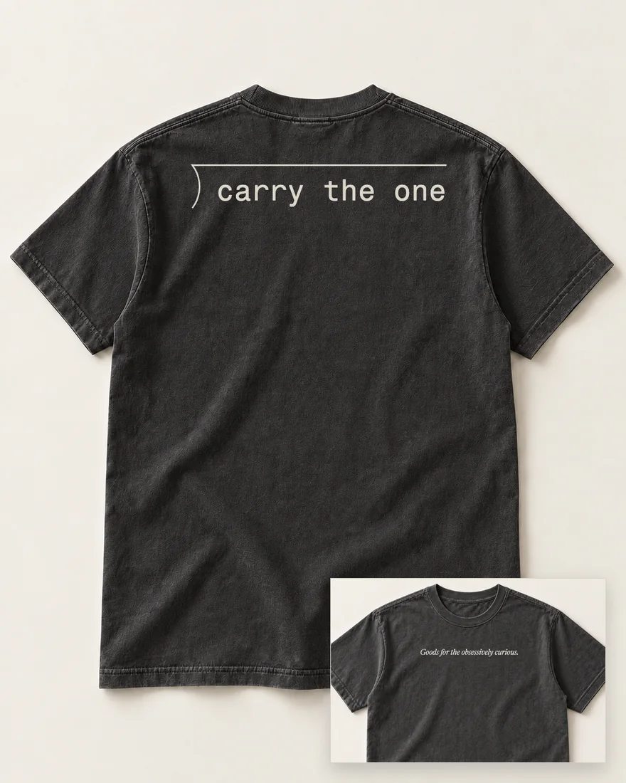 A washed black tee, back up: the long-division bracket with carry the one under its bar.